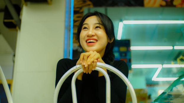 Woman with fresh, glowing skin smiling in a bright cafe