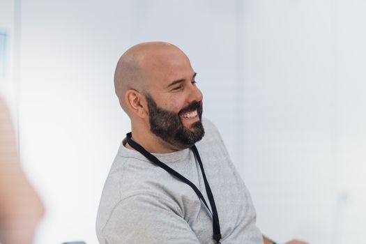 Man in his forties with a relaxed expression in a bright office