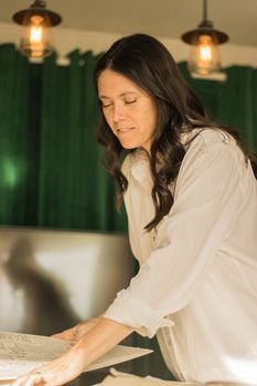 Woman in her forties looking at her cheek in a mirror