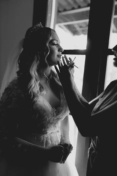 Bride getting ready by a sunny window