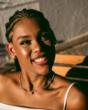 Woman with an even skin tone smiling outdoors in soft afternoon light