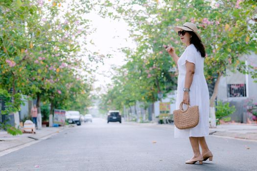 Woman in a wide-brim hat and sunglasses on a sunny Seoul street