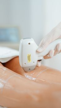 Laser hair removal treatment being performed on a lower leg