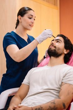 Man receiving a facial treatment in a modern clinic