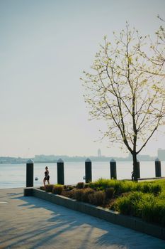 Woman jogging along a riverside path in the morning