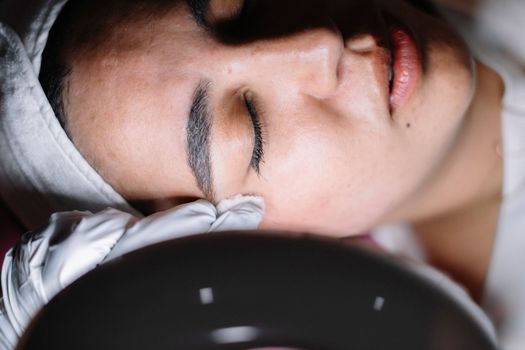 Woman with eyes closed relaxing during a facial treatment