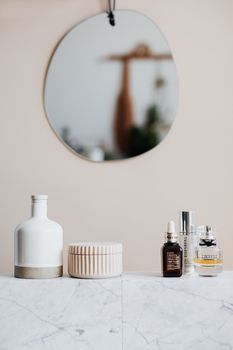 Unlabeled skincare dropper bottle on a bathroom shelf in soft light