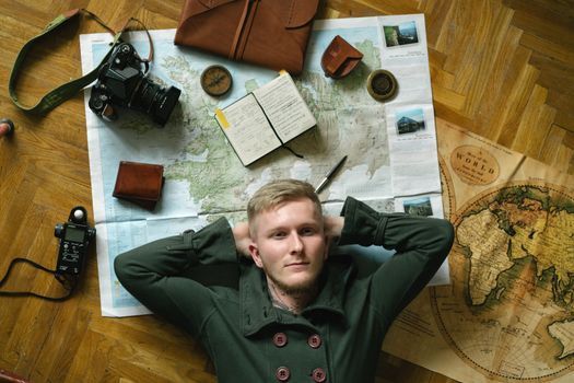 A traveler planning an itinerary with a paper map and notebook in a cafe