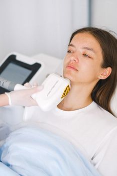 Aesthetic doctor applying a radiofrequency device to a woman’s forehead in a calm treatment room