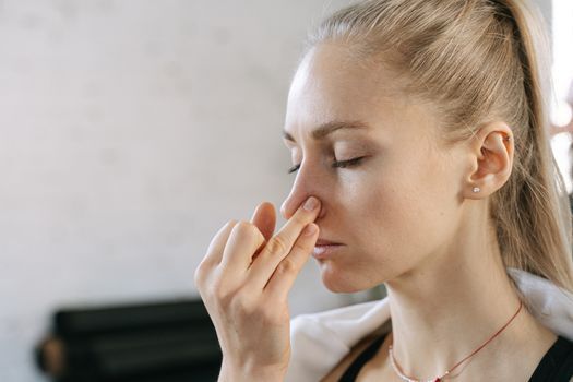 Close-up of a woman blotting her nose with oil control paper