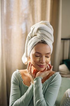 Woman gently touching the skin under her eyes in morning light