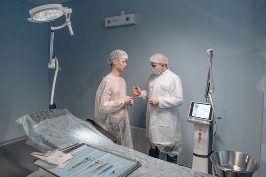 Doctor examining the skin on a young man’s cheek