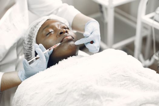 Numbing cream being applied to a woman's face before a skin booster treatment