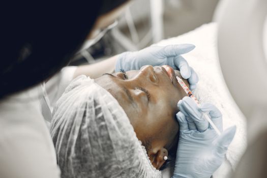 Doctor performing a hyaluronic acid injection on a woman's neck