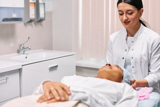 Woman with fresh, glowing skin sitting in a bright treatment room