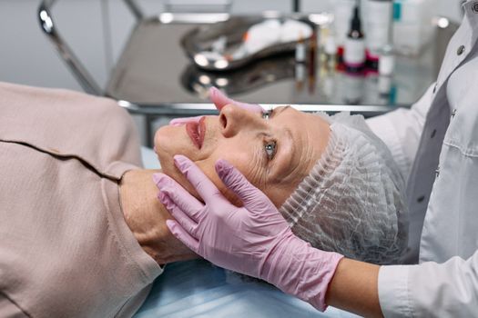 Doctor assessing cheek and temple volume during a consultation