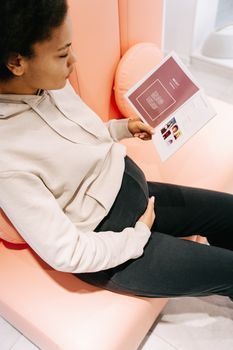 A woman reading an information leaflet in a bright clinic waiting area