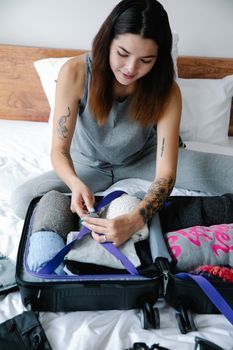 Woman packing a suitcase in a hotel room