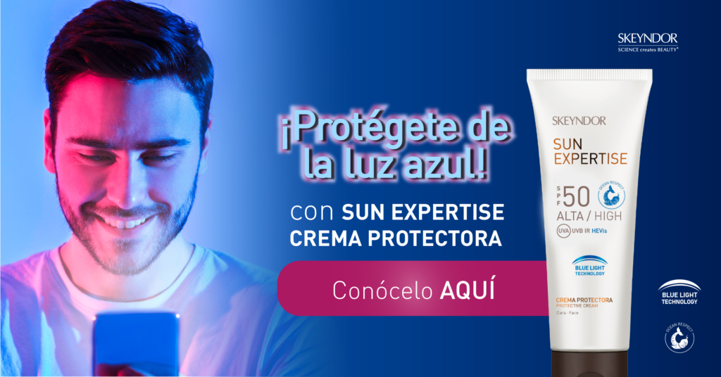 Un hombre mira un teléfono móvil junto a un tubo de crema protectora solar.