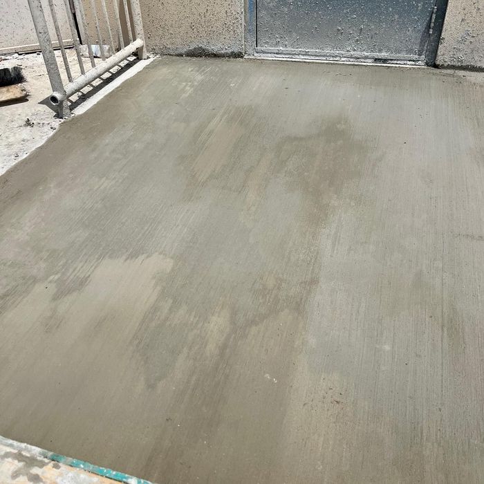 Freshly smoothed gray concrete floor in an unfinished indoor area