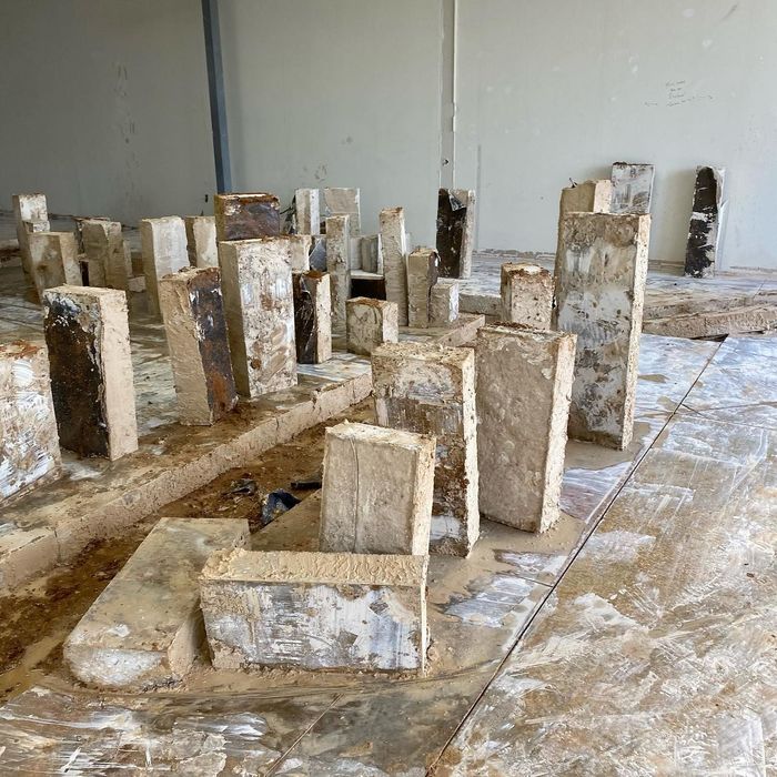 Rows of weathered white concrete blocks standing on a dusty floor in an unfinished room