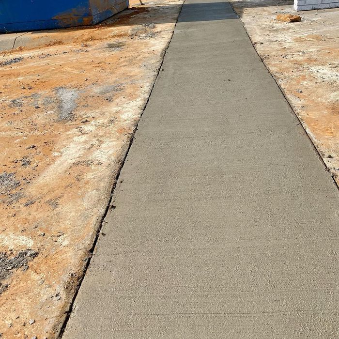 New concrete sidewalk between blue and orange construction areas