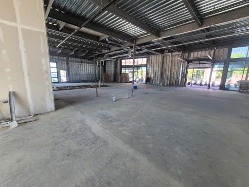 Empty unfinished warehouse interior with exposed steel framing and concrete floor