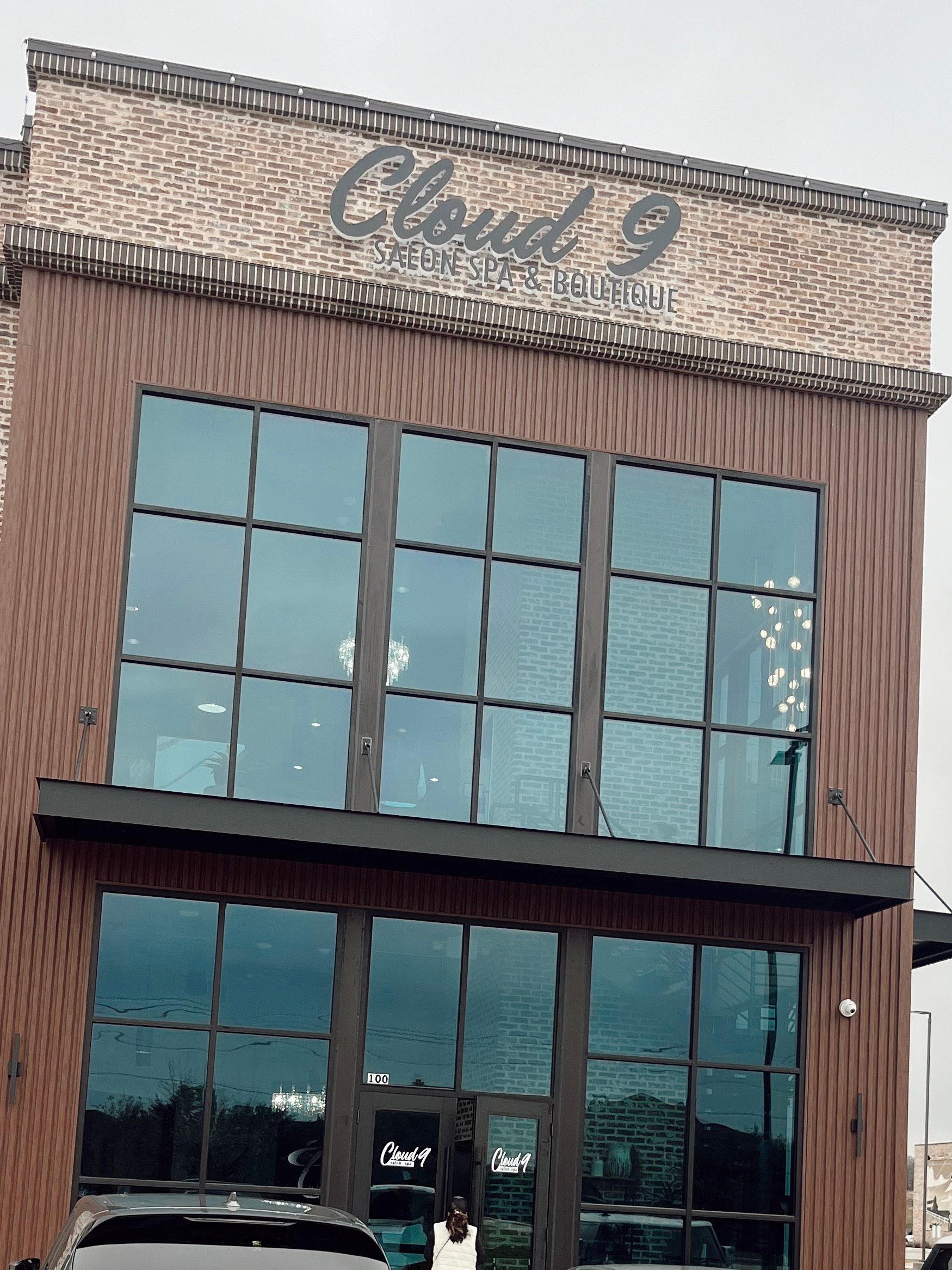 Cloud 9 storefront with large windows and brown siding on a brick building