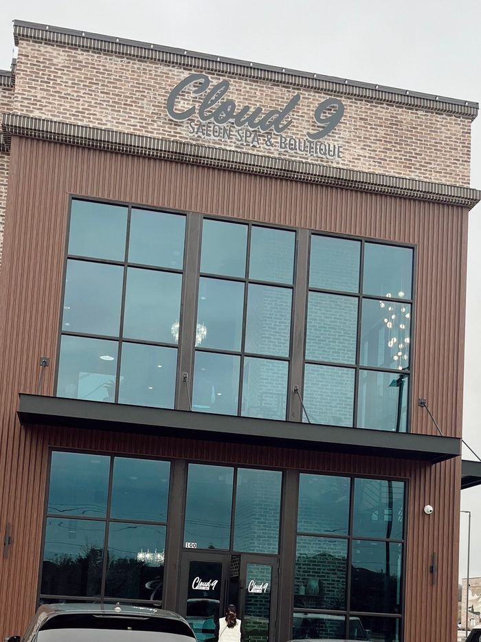 Storefront labeled “Cloud 9” with large windows and brown siding