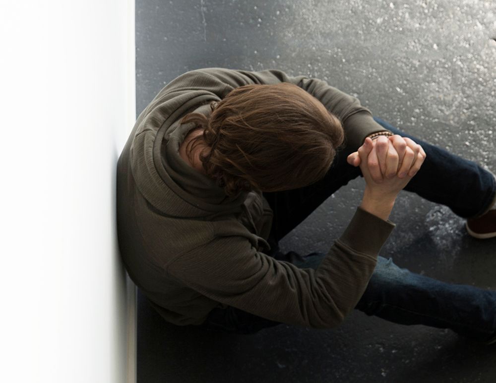 Man with anxiety sitting on ground