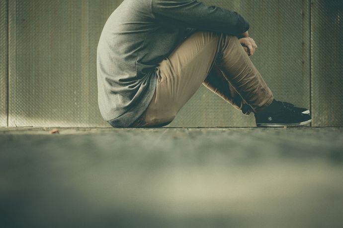 Man sitting on hard surface and thinking