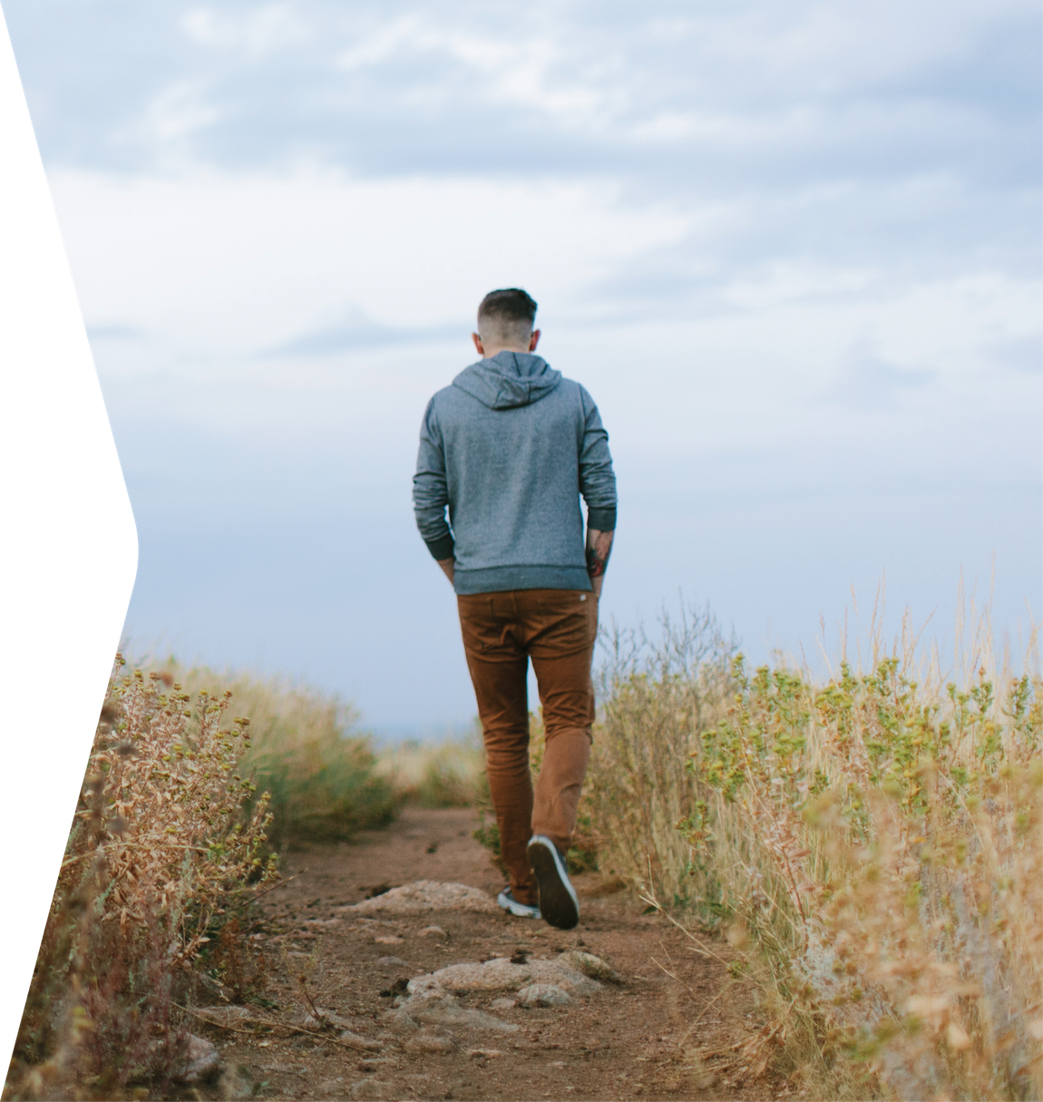 Somber man walking in meadow