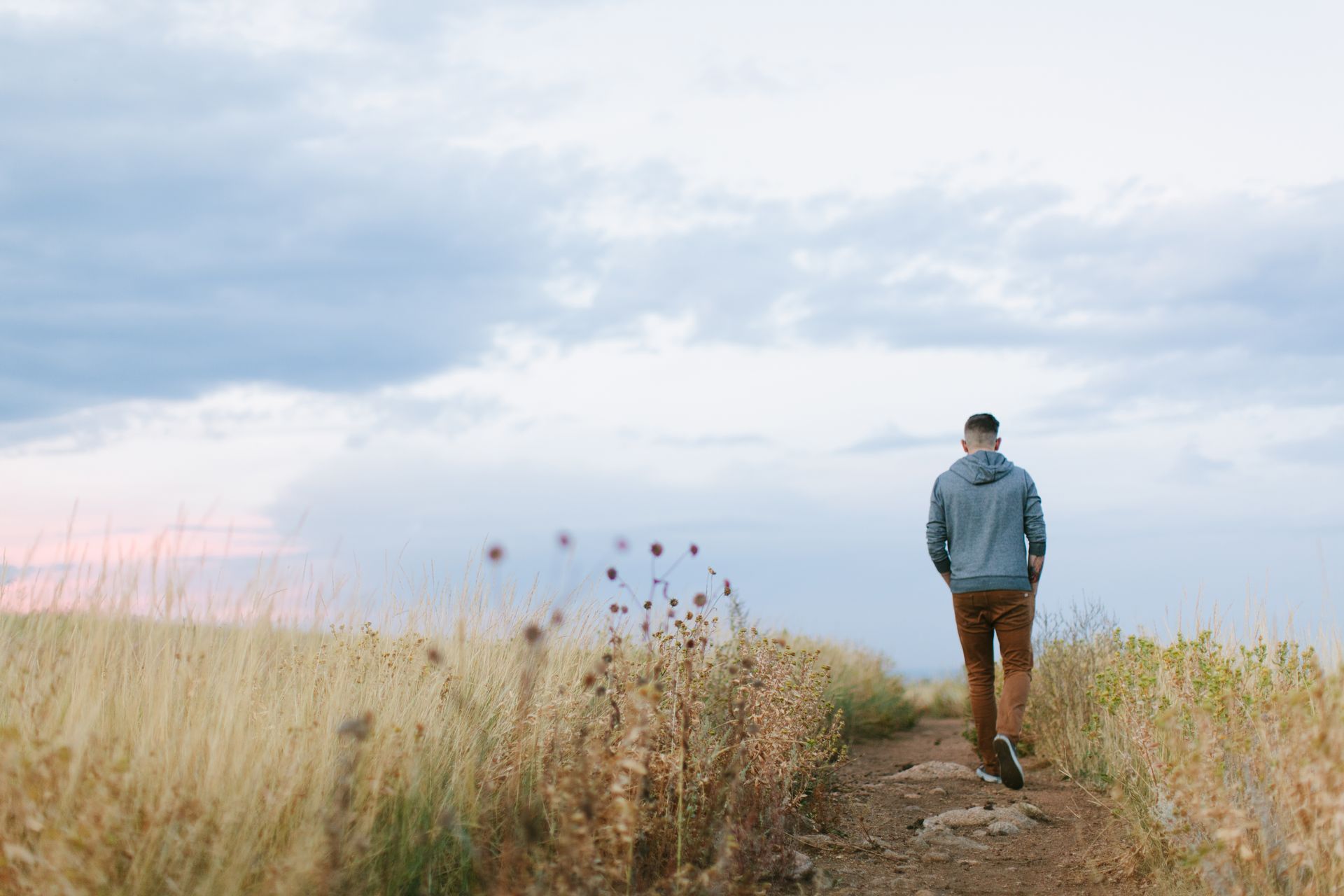 man standing on a mountain overlooking a wide landscape