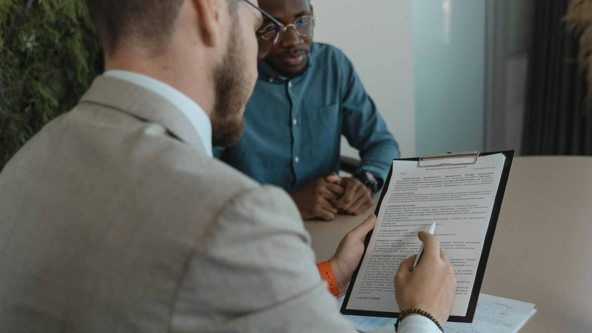 Attorney reviews a legal document with a client during a consultation, discussing contract terms and