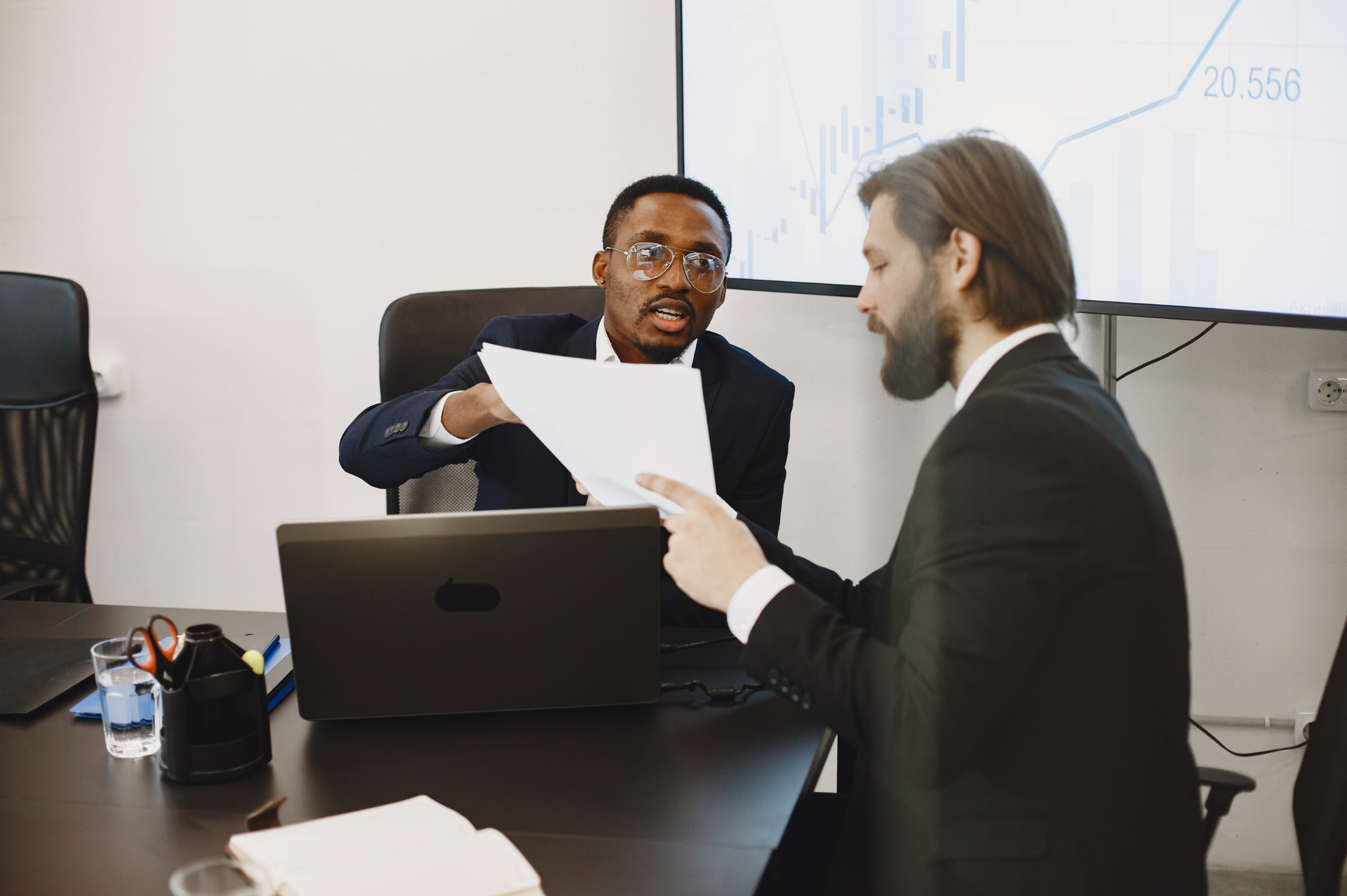 Business professionals reviewing documents during a meeting about a potential legal dispute.