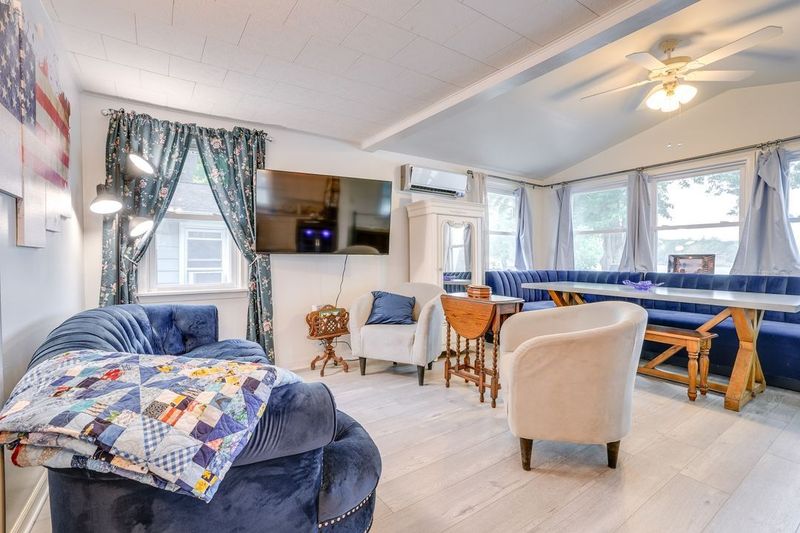 Cozy living room with blue furniture, built-in booth seating, and a TV mounted on the wall.