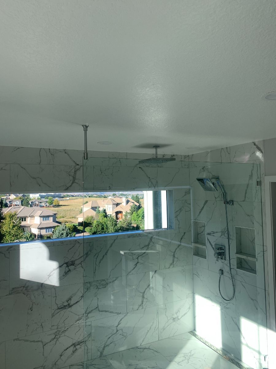 a bathroom with a walk in shower and a large mirror