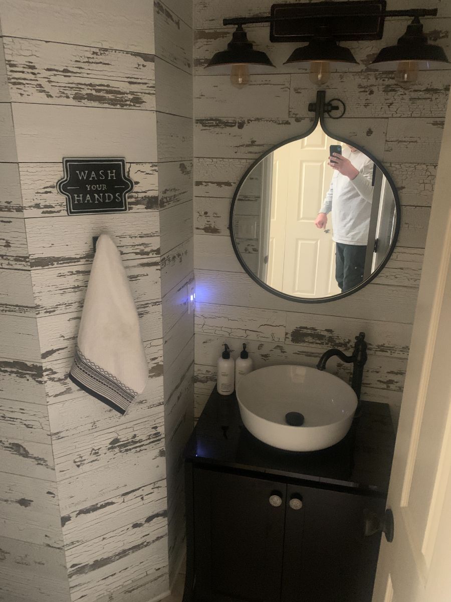 a bathroom with a sink , mirror and towel rack .