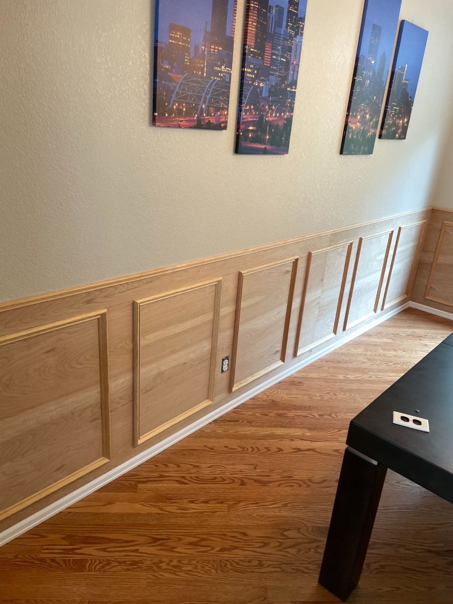 a living room with wood paneling on the wall and a table