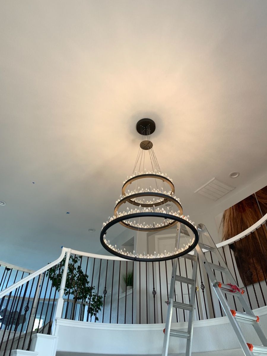a large chandelier is hanging from the ceiling in a living room .