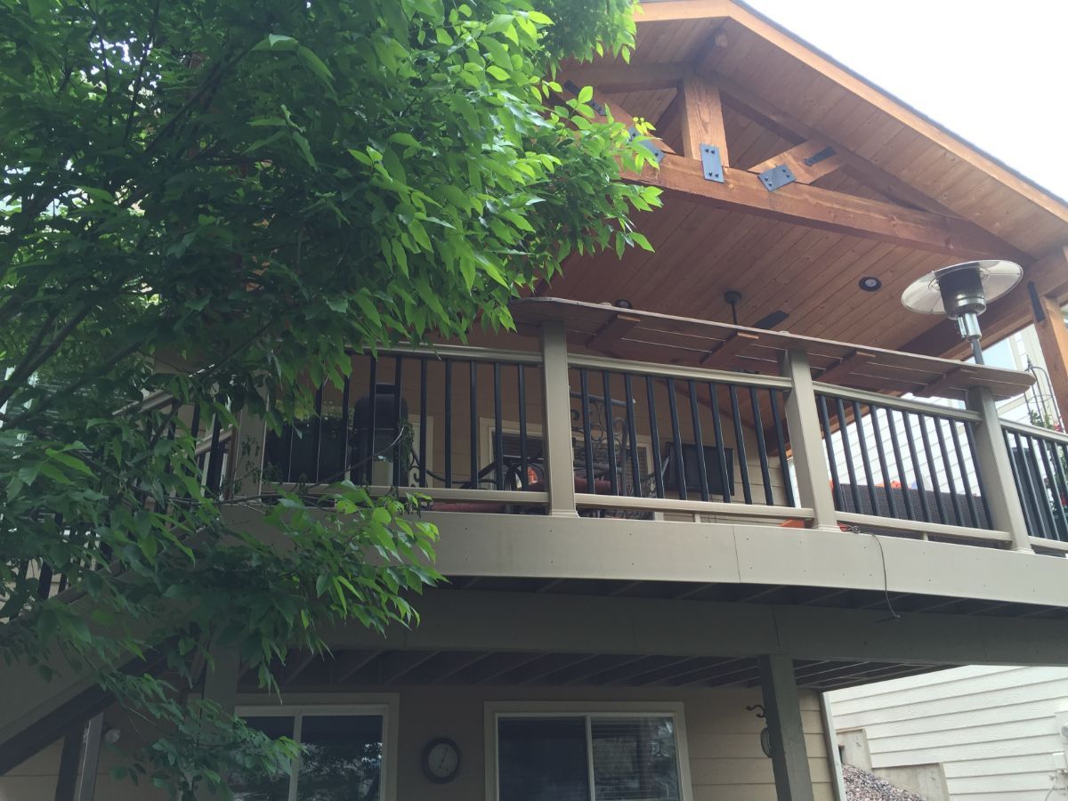 a house with a balcony and a tree in front of it