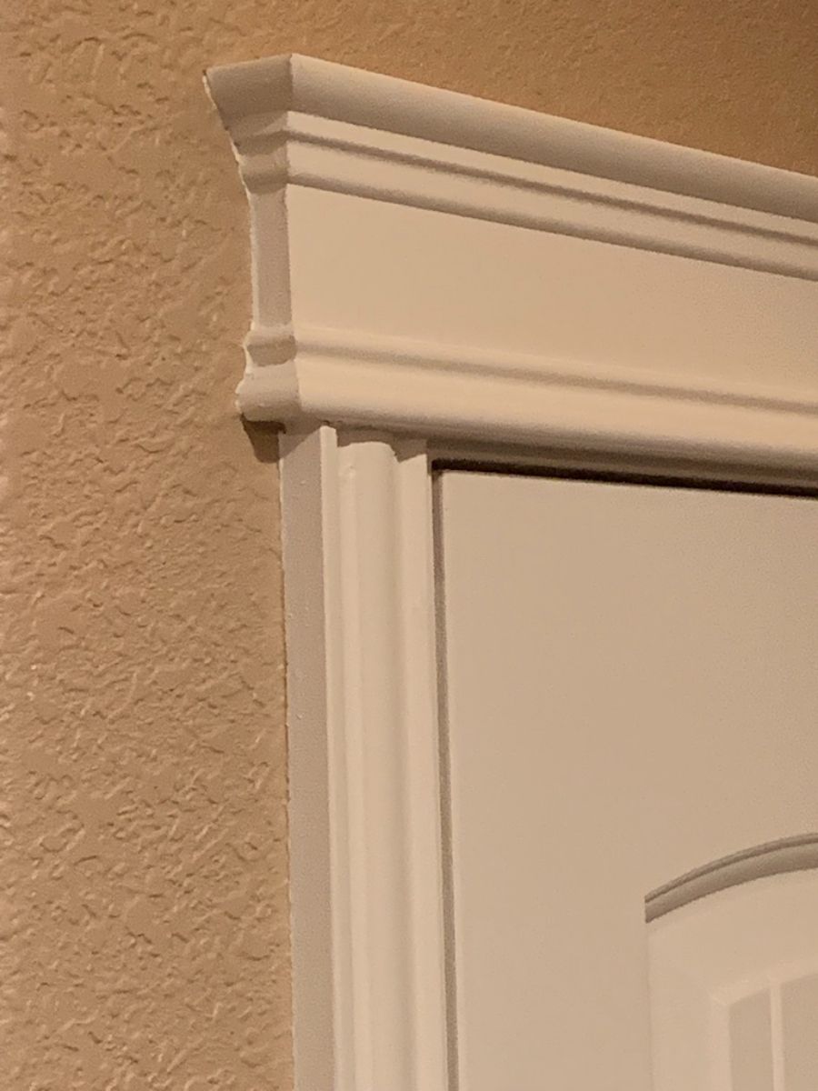 a white door with a white trim on it is against a tan wall .