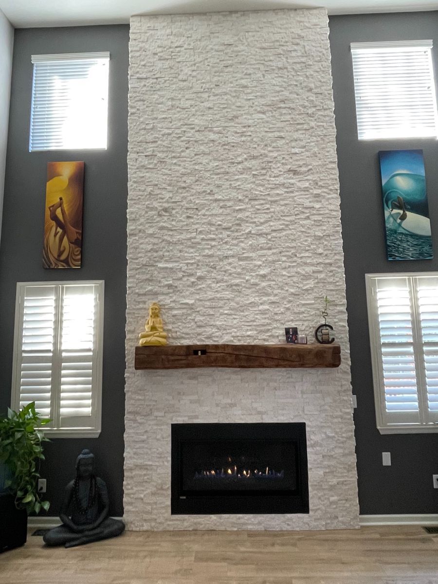 a living room with a fireplace and shutters on the windows