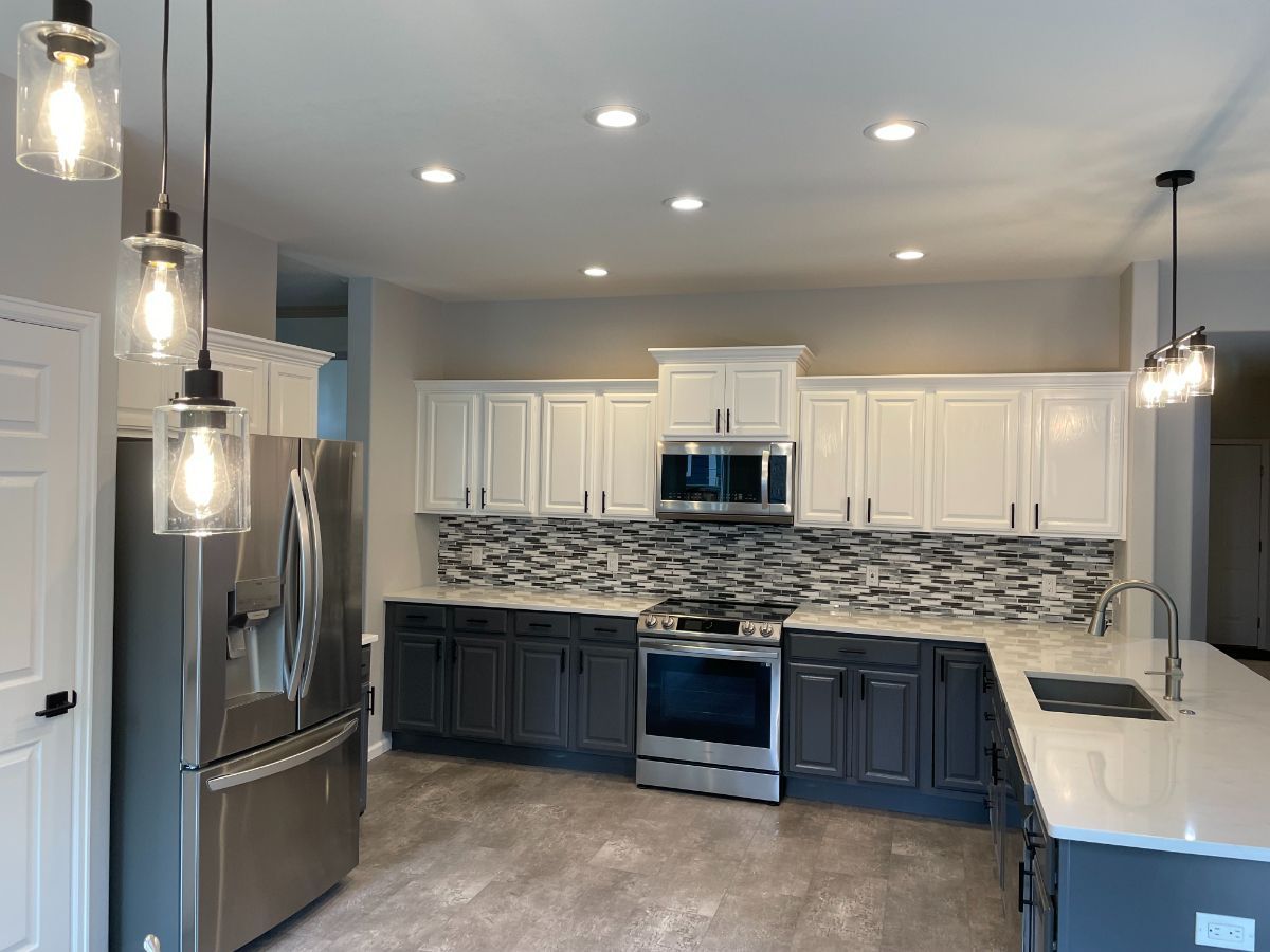a kitchen with stainless steel appliances and white cabinets .