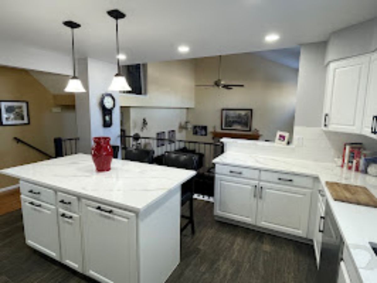 a kitchen with white cabinets and a large island