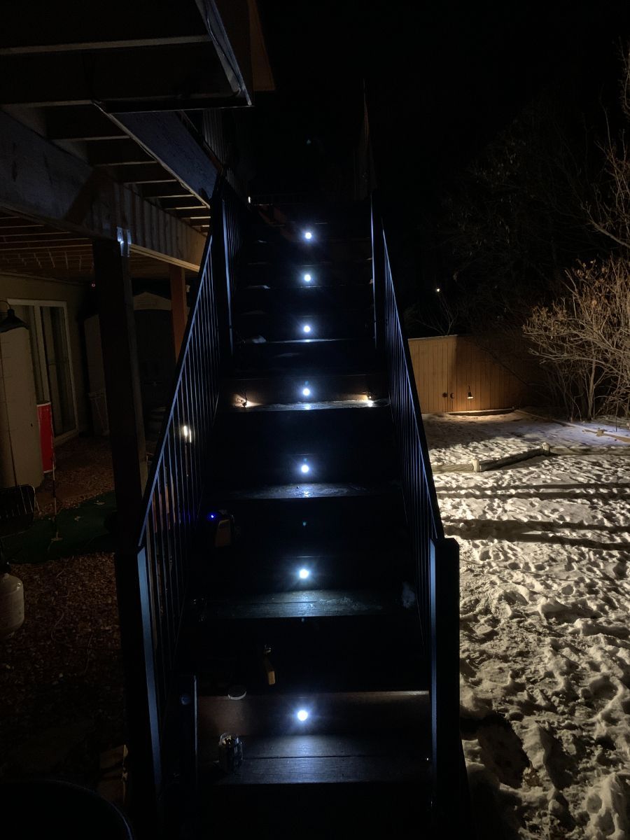 a set of stairs with lights on them at night .