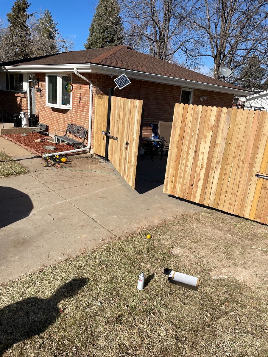 a wooden fence is being built in front of a brick house .