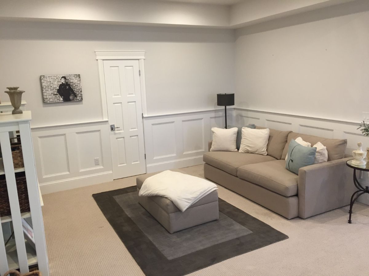 a living room with a couch , ottoman and rug .