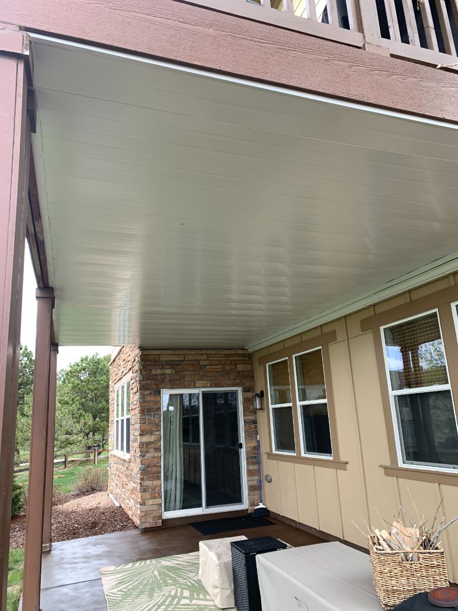 a house with a rain-out covered porch and a sliding glass door .