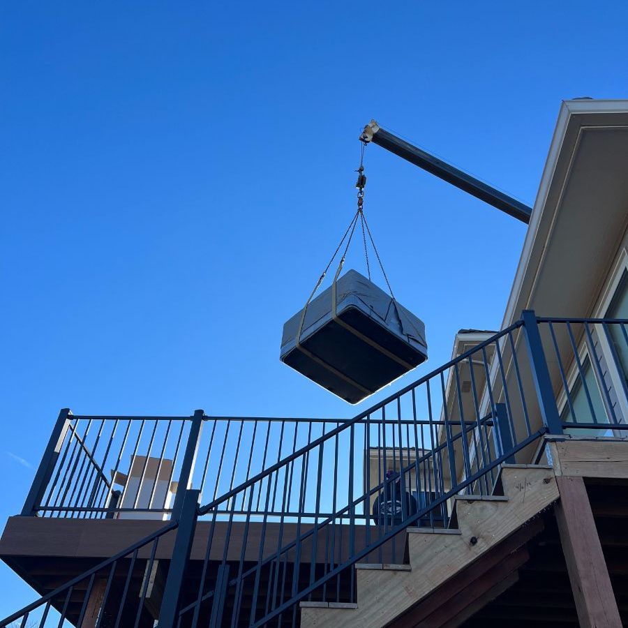a large box is being lifted by a crane from a deck